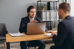 um homem realiza uma reunião de negócios e assina um contrato, emprego ou acordo. foto