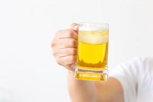 mão masculina segurando um copo de cerveja, mão segurando a caneca de cerveja fazendo um brinde foto