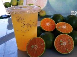 suco de laranja e fatias de laranja espremidas foto