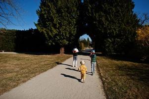 três crianças andando no parque lednice, república tcheca. foto