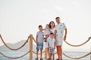 família com três filhos na turquia resort contra o mar mediterrâneo fica no cais. foto