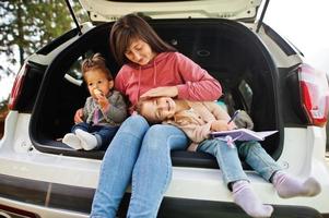 família no interior do veículo. mãe com suas filhas. crianças no porta-malas. viajando de carro nas montanhas, conceito de atmosfera. foto