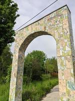 portão de pedra em um parque. portão de proa na natureza foto