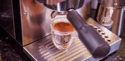espresso marrom dourado fresco em uma máquina de café expresso de aço foto