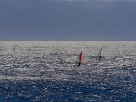 dois windsurfistas ondas de crista de água azul foto