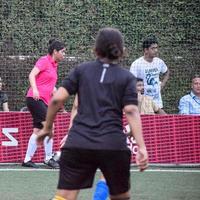 nova delhi, índia - 01 de julho de 2018 mulheres futebolistas do time de futebol local durante o jogo no campeonato regional derby em um campo de futebol ruim. momento quente da partida de futebol no estádio de grama verde foto