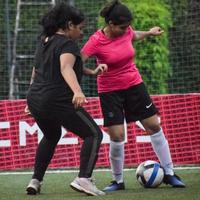 nova delhi, índia - 01 de julho de 2018 mulheres futebolistas do time de futebol local durante o jogo no campeonato regional derby em um campo de futebol ruim. momento quente da partida de futebol no estádio de grama verde foto