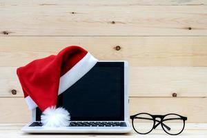 laptop com tela em branco e chapéu de papai noel foto