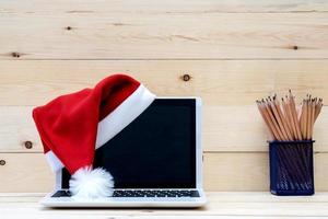 laptop com tela em branco e chapéu de papai noel foto