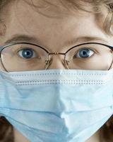 retrato de uma jovem de óculos e um close-up de máscara médica. epidemia de gripe, alergia à poeira, proteção contra vírus. pandemia do coronavírus. foto