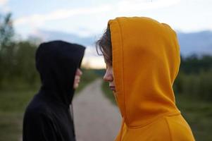 dois adolescentes ao ar livre. moda jovem. problemas da idade de transição. o cara em desfoque. foto