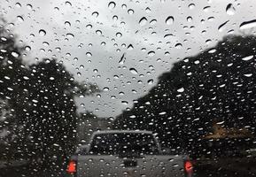 gotas de chuva de água em uma textura de fundo abstrato de vidro de carro foto