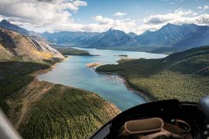 dentro de um helicóptero voando em montanhas rochosas com lago colorido foto