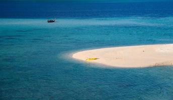 a praia branca com canoa amarela no mar tropical foto