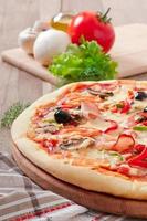 pizza com presunto, cogumelos e azeitonas foto