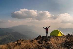 jovem viajante com mochila acampando na montanha, conceito de estilo de vida de viagens de aventura foto