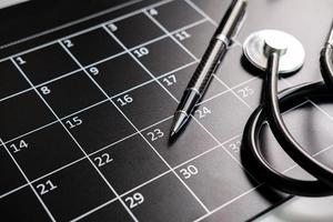 estetoscópio com calendário, consulta médica e conceito de check-up anual foto