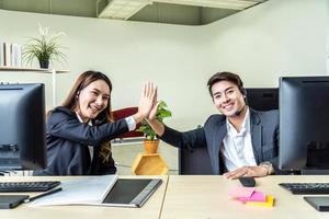 homens e mulheres de negócios com fone de ouvido como call center ou televendas de negócios na mesa no escritório de atendimento ao cliente dando mais cinco para ficar satisfeito com o sucesso foto