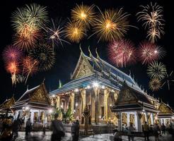 celebração de fogos de artifício em wat phrasrirattana sasadaram o templo do buda esmeralda, wat phra kaeo na noite em bangkok, tailândia foto