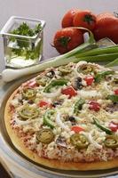 deliciosa pizza com legumes ao seu redor em ambiente. foto