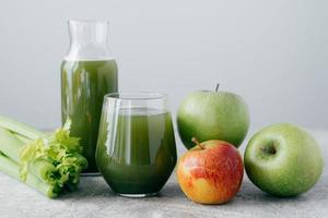 smoothie verde fresco com ingredientes. conceito de bebida de superalimento e desintoxicação. maçãs frescas e cerely em fundo branco. bebida saudável foto