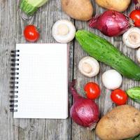 legumes frescos e um caderno de receitas