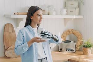 garota com deficiência europeia está segurando o copo com a mão cibernética. tecnologias para a qualidade de vida. foto