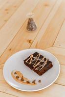 xícara de café cappuccino quente na mesa com bolo de chocolate foto