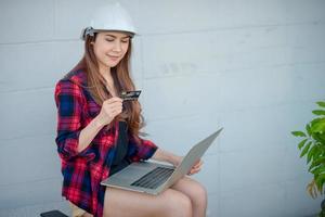 engenheira de construção feminina está assistindo cartões de crédito foto