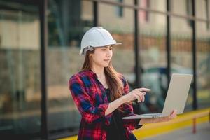 uma engenheira de construção feminina usando um laptop foto