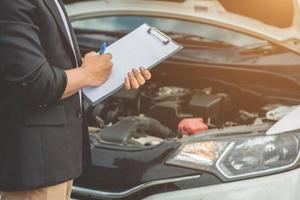 o mecânico que atende o carro está registrando os resultados da inspeção do carro. foto