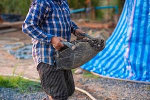 trabalhadores da construção estão carregando pedras para misturar com cimento. foto