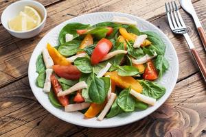 salada de lula cozida, tomate fresco, folhas de espinafre. delicioso prato de dieta brilhante com legumes e frutos do mar. foto