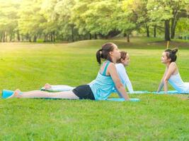 grupo de mulher bonita relaxante com ioga no parque ao ar livre foto