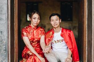 feliz jovem casal asiático em vestidos tradicionais chineses foto