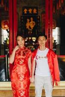 feliz jovem casal asiático em vestidos tradicionais chineses foto