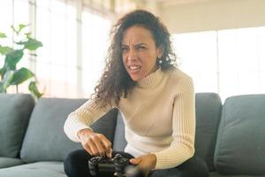 mulher laitin jogando videogame com as mãos segurando um joystick foto