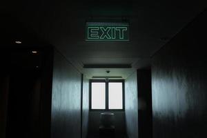 sinal de saída no corredor escuro foto