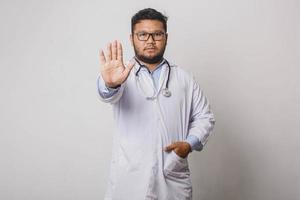 médico masculino sério gesticulando para parar isolado no fundo branco foto