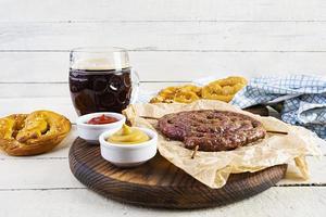 menu de comida para oktoberfest. salsicha com molho diferente, pretzel e copo de cerveja escura foto