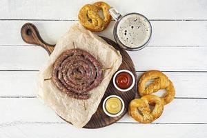 menu de comida para oktoberfest. salsicha com molho diferente, pretzel e copo de cerveja escura foto