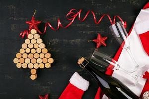 decoração de ano novo com árvore de natal feita de rolhas de vinho e garrafa de champanhe. fundo de natal. vista do topo. foto