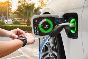 veículo elétrico mudando no estacionamento na rua com interface gráfica do usuário sincronizado com relógio inteligente, futuro conceito de carro ev foto