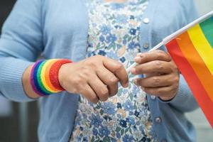 senhora asiática com coração de bandeira do arco-íris, símbolo do mês do orgulho lgbt comemora anual em junho social de gays, lésbicas, bissexuais, transgêneros, direitos humanos. foto