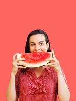 mulher alegre segurando um pedaço de melancia fatiada. conceito de verão foto