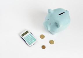 ilustração de contar dinheiro. cofrinho azul com calculadora e moedas em fundo branco foto