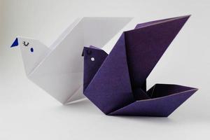 dois pássaros de papel origami em fundo branco foto