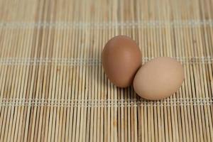 ovos em uma cesta na mesa de madeira foto