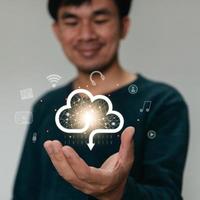 empresário segurando um ícone de dados de nuvem com luz. dados de computação na rede. conceito de segurança de computador de negócios de seguros. foto