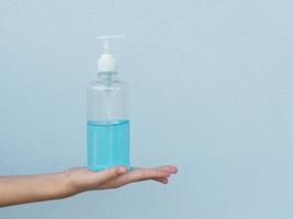 mulher segurando gel de álcool na mão para lavagem prevenir vírus e bactérias foto